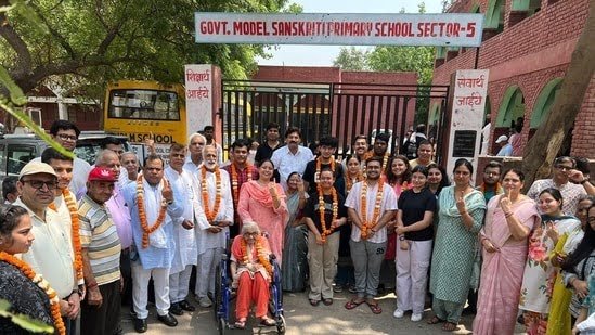 Delhi Lok Sabha polls: Mira Devi, 85, and children voting for the first time were honoured with flower garlands by the RWA in sectors 3, 5, and 6 in New Delhi on Saturday.(HT Photo)